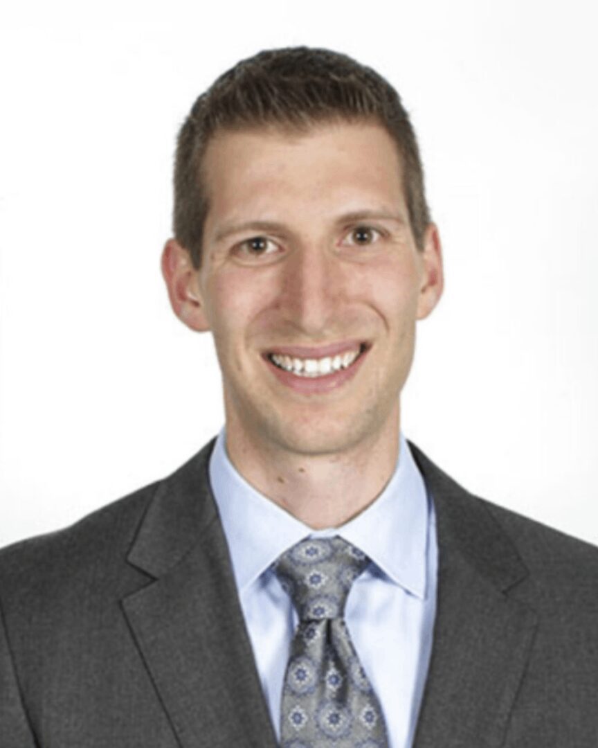 A man in suit and tie smiling for the camera.