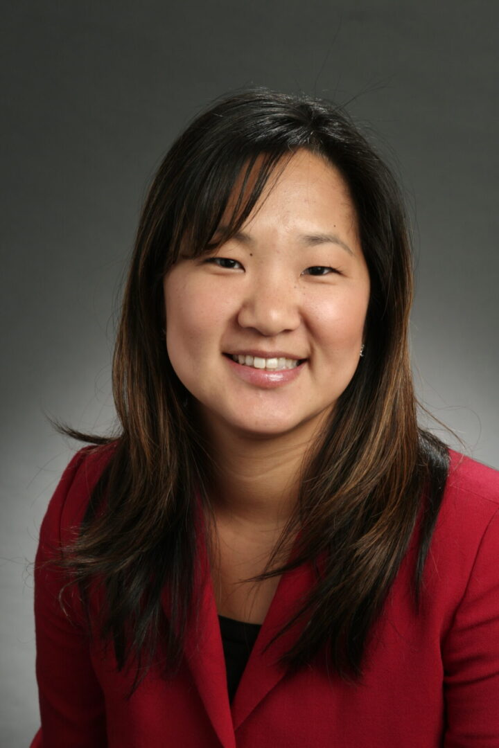 Lacey Robb Headshot_2 A woman with long hair and wearing red shirt.