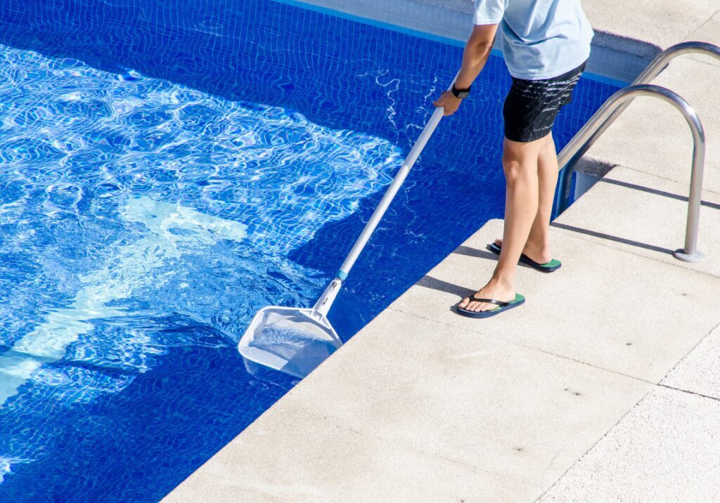 Pool service technician cleaning a swimming pool